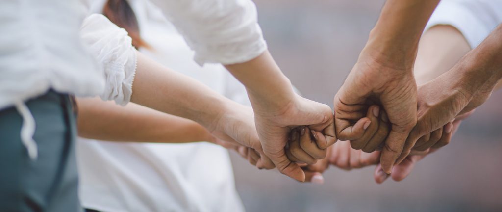 people fist bumping for unified communications