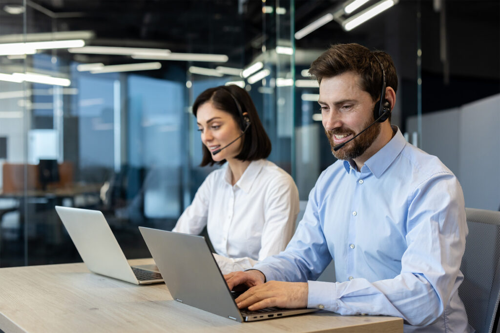 Blog image showing 2 call centre workers on computers and headsets